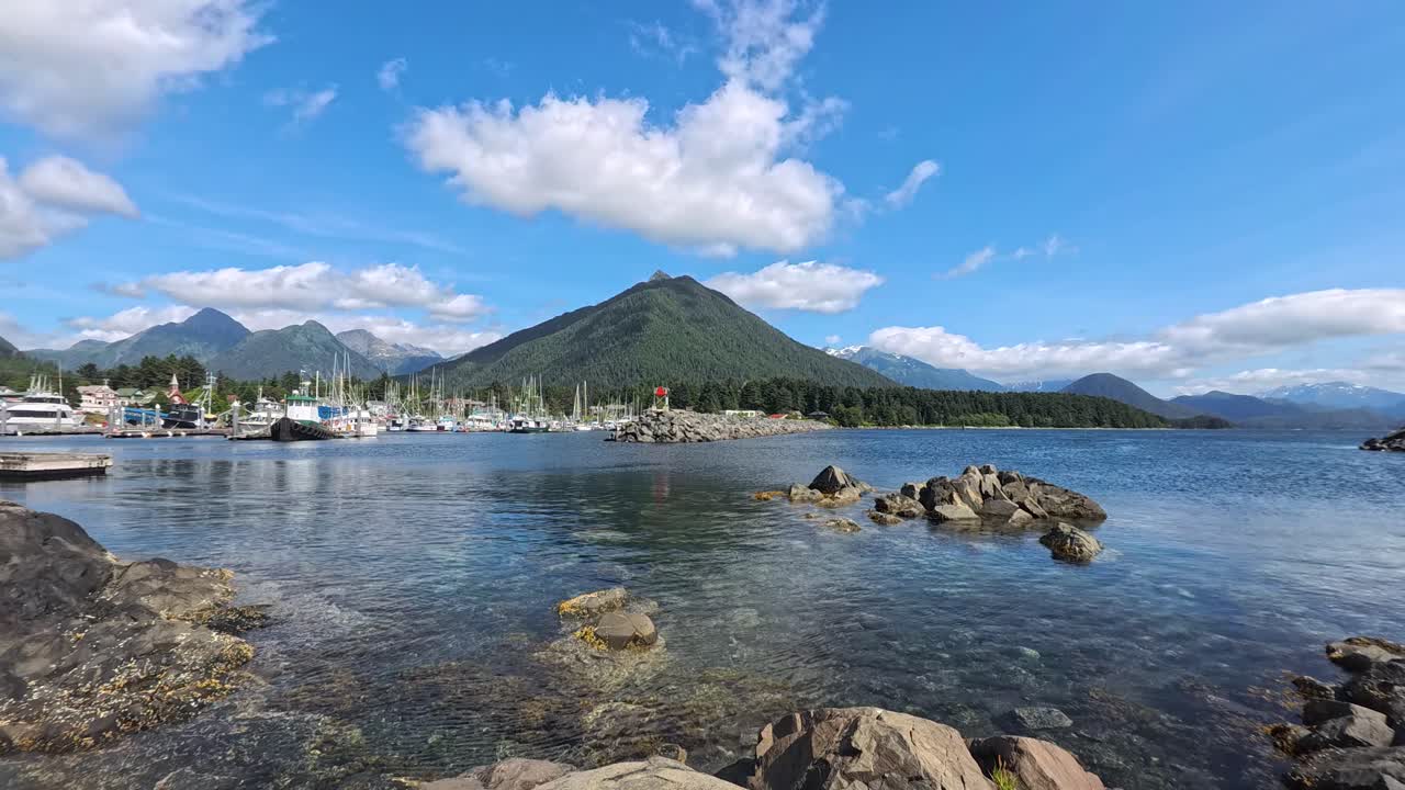 Baia panoramica con barche nel porto turistico e montagne boscose