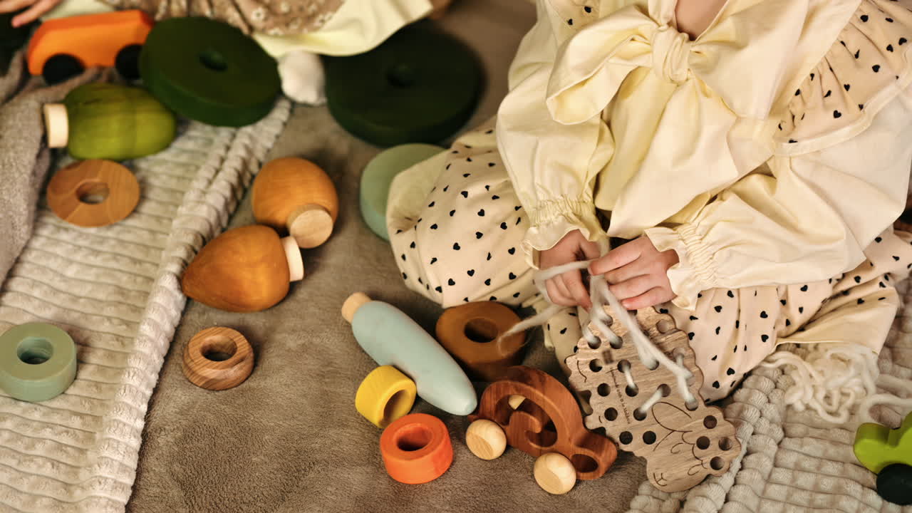 Overhead view of two little girls playing with wooden toys on the bed. Ecological and sustainability concept