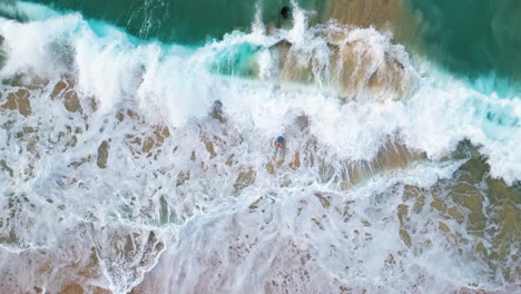 Slow-motion-shot-of-tourists-against-the-waves-on-Oahu-Hawaii-beach--top-view