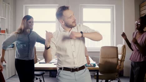 young caucasian male executive doing a funny victory dance at fun casual office party, celebrate business achievement 4k