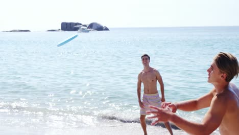 Friends-playing-frisbee-at-beach