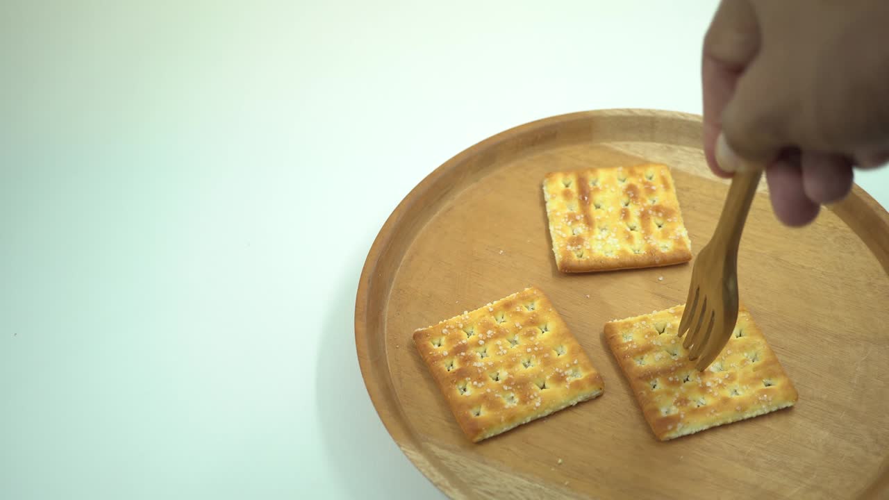 galleta de navidad sobre el plato de madera, tenedor y cuchara con fondo blanco.
