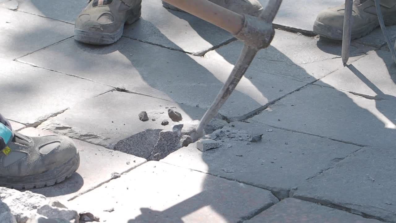 Workers Repairing Damaged Paving Stones