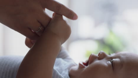 Madre-Sosteniendo-La-Mano-Del-Bebé-Tocando-Los-Dedos-Cuidando-Al-Recién-Nacido-Cuidando-Al-Bebé-En-Casa-Disfrutando-De-La-Maternidad