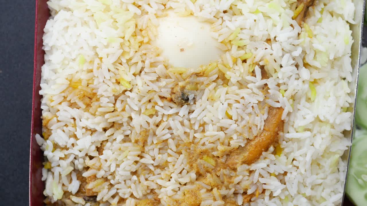 Comida de biryani de pollo en un recipiente sobre la mesa