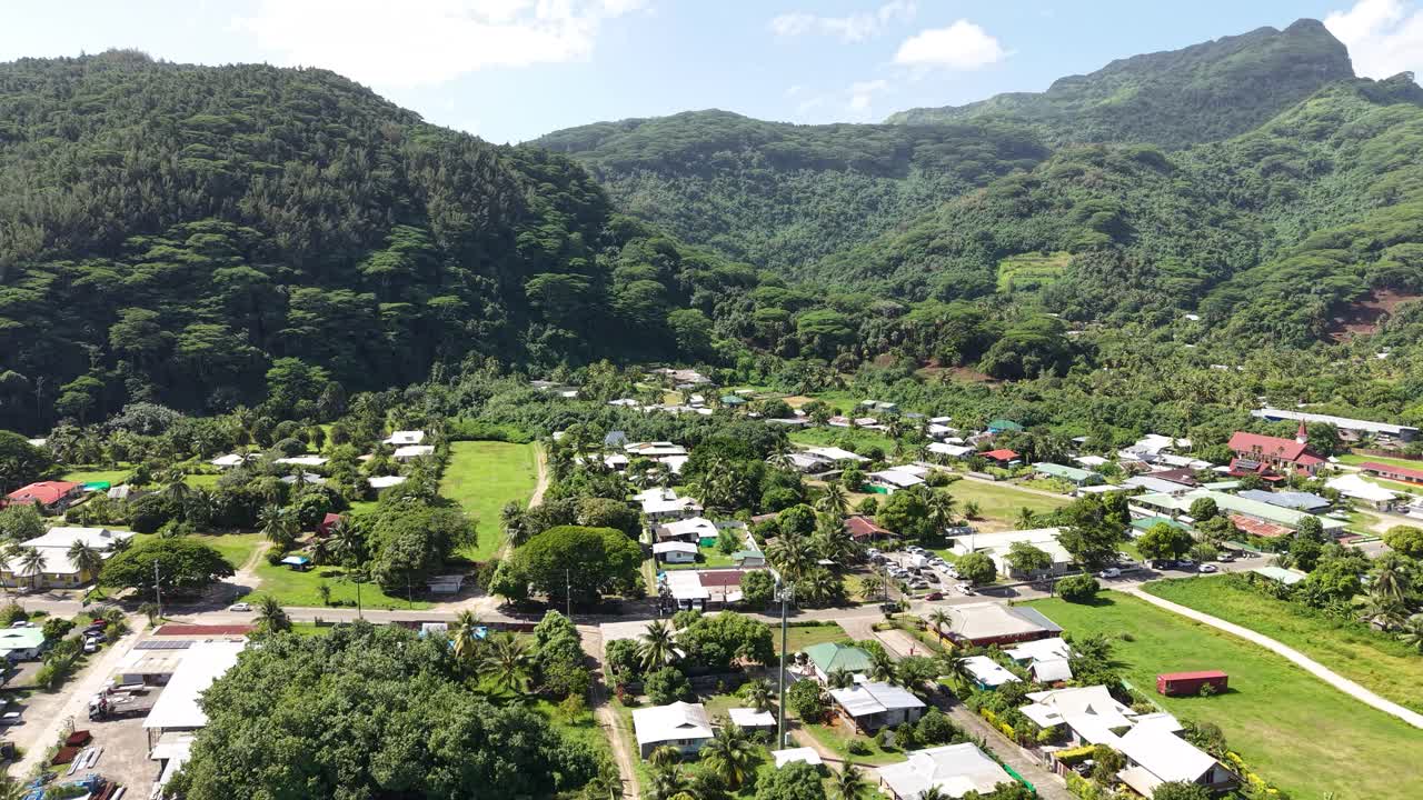 Aerial View of Fare Village on HUahine Island, French Polynesia. Homes and Street Traffic Under Green Hills With Tropical Rainforest