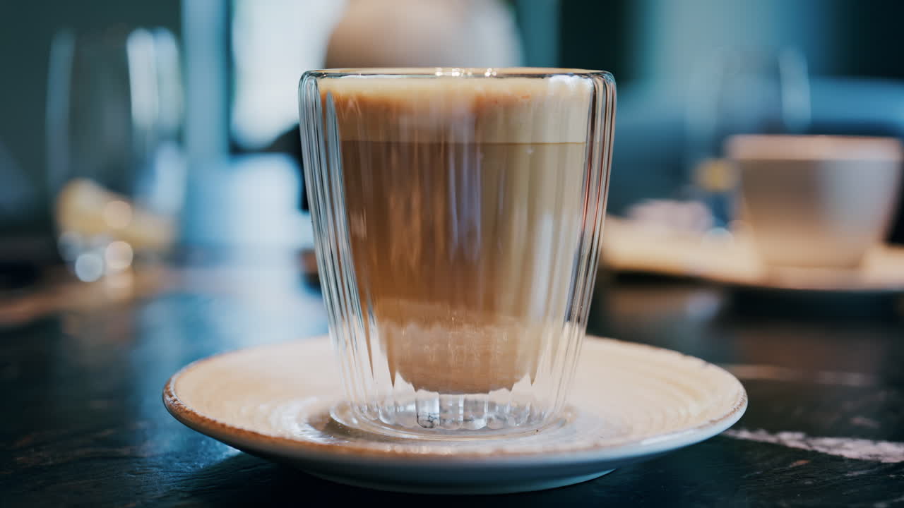 Close up of a glass cup with a latte at a cafe