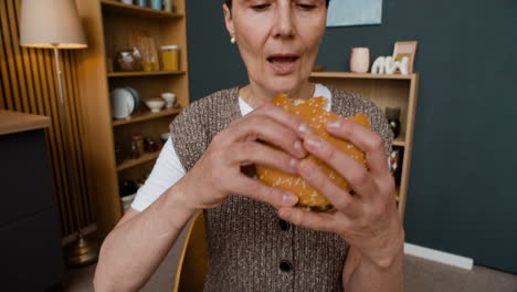a woman eating a fast food meal with a burger, fries, and nuggets