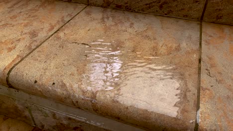 el agua de lluvia corre por los escalones de piedra