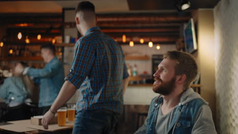 A-group-of-people-in-a-pub-cheers-for-their-national-team-at-the-World-Cup.-Enjoys-scoring-a-goal-while-sitting-at-the-table-with-a-beer.-Fans-celebrate-a-goal-by-watching-TV-in-a-bar.