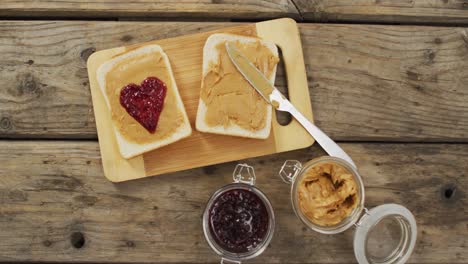 Close-up-view-of-peanut-butter-and-jelly-sandwich-on-wooden-tray-on-wooden-surface