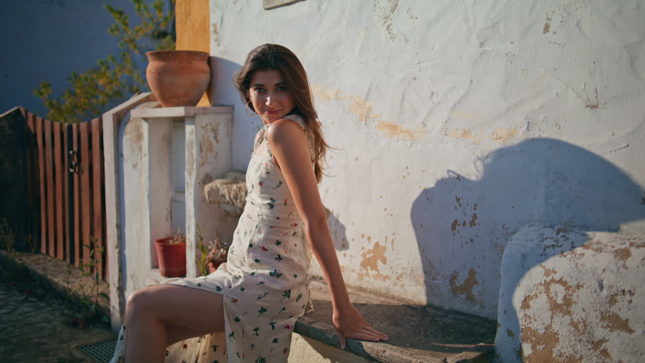 mujer sexy mirando el sol descansando viejo banco de la aldea. dama romántica tocando el cabello