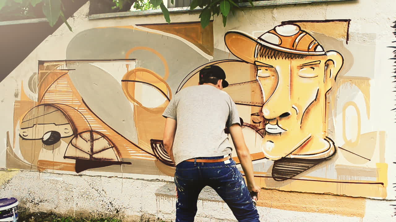 El artista dibuja grafitis en una valla. Grafiti en una valla.