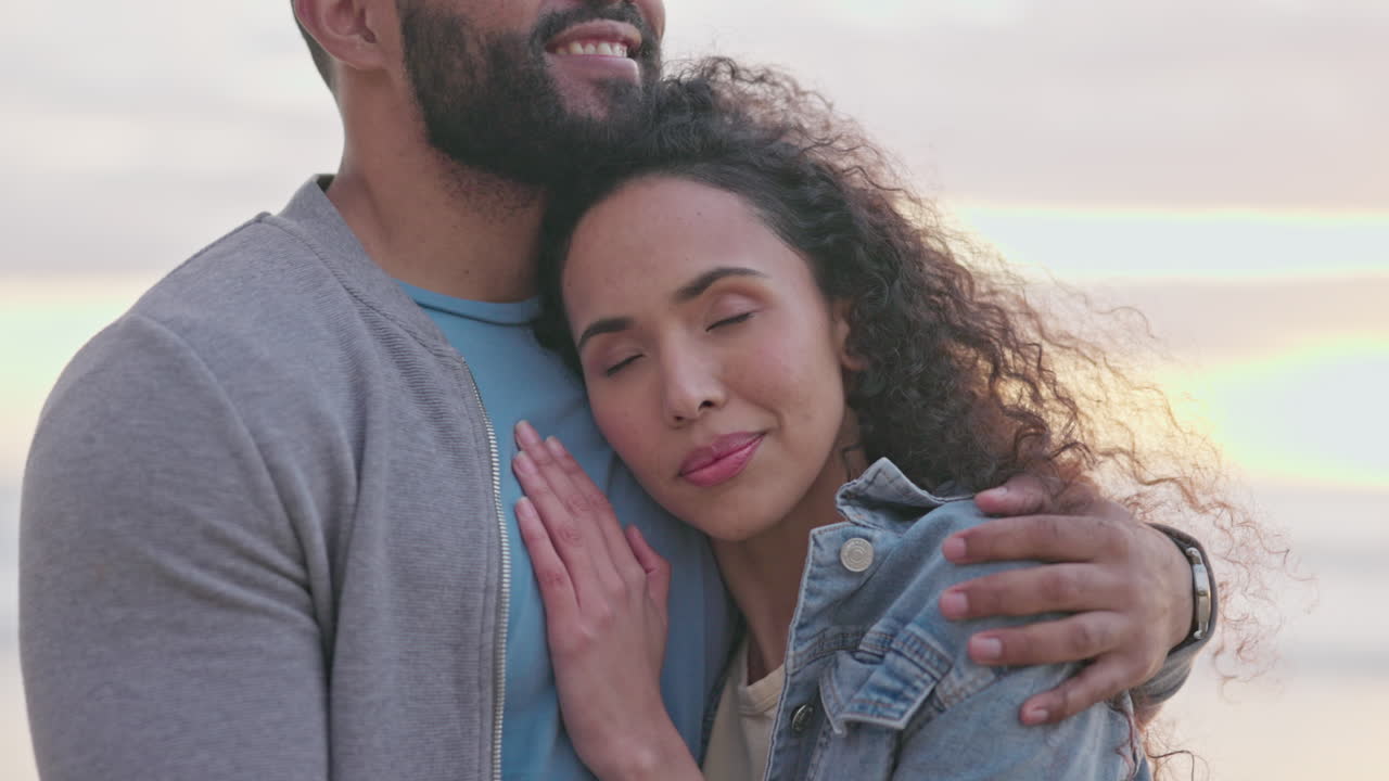 abrazo, amor y pareja en la playa al atardecer