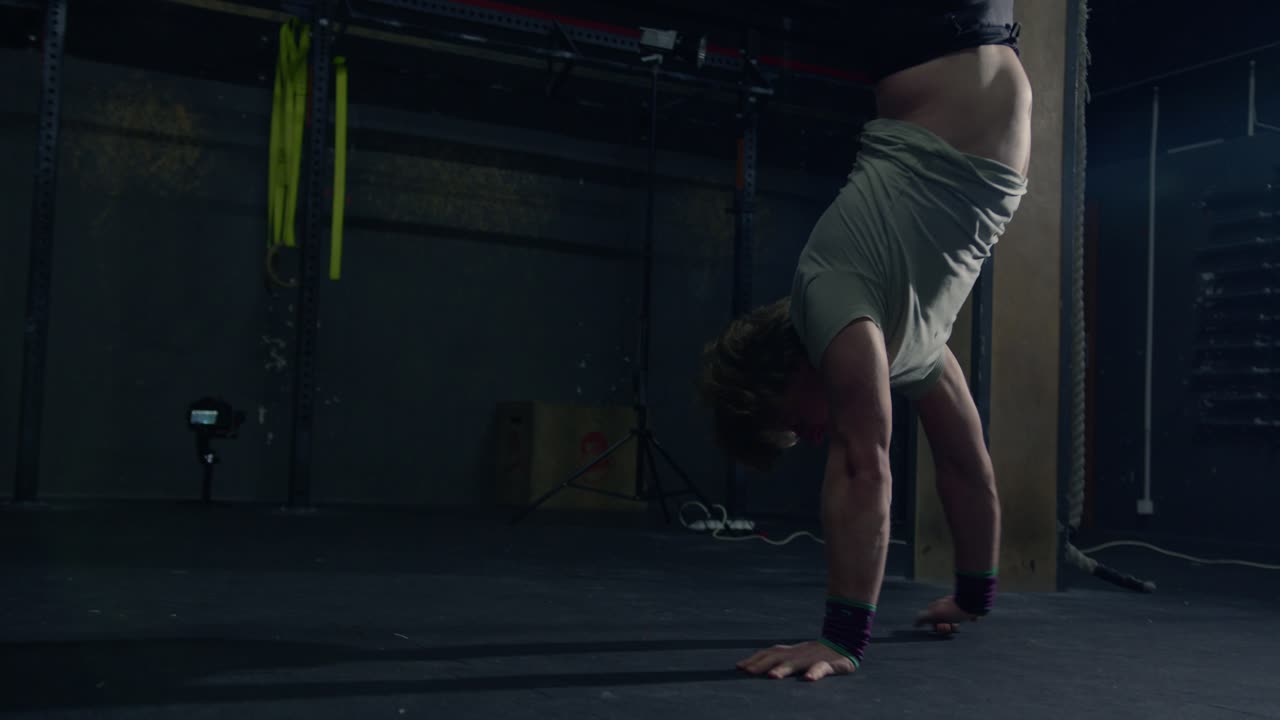 hombre caminando hacia adelante haciendo parada de manos en una caja de crossfit