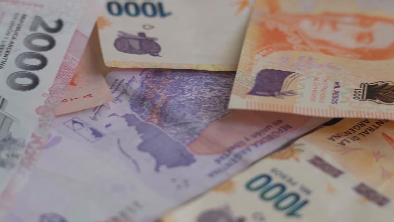primer plano de billetes argentinos de diferentes denominaciones, desplazándose de izquierda a derecha