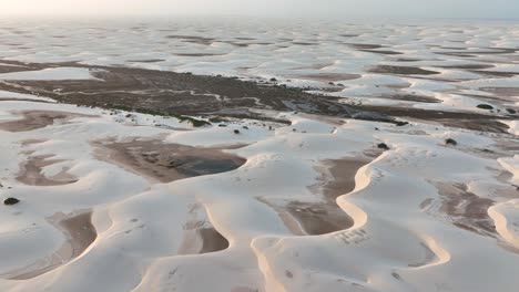 slow motion drone aerial over white sand dunes and lagoons at lencois maranhenses national park, brazil. dolly in