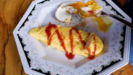 a person eating a fried egg and omelette