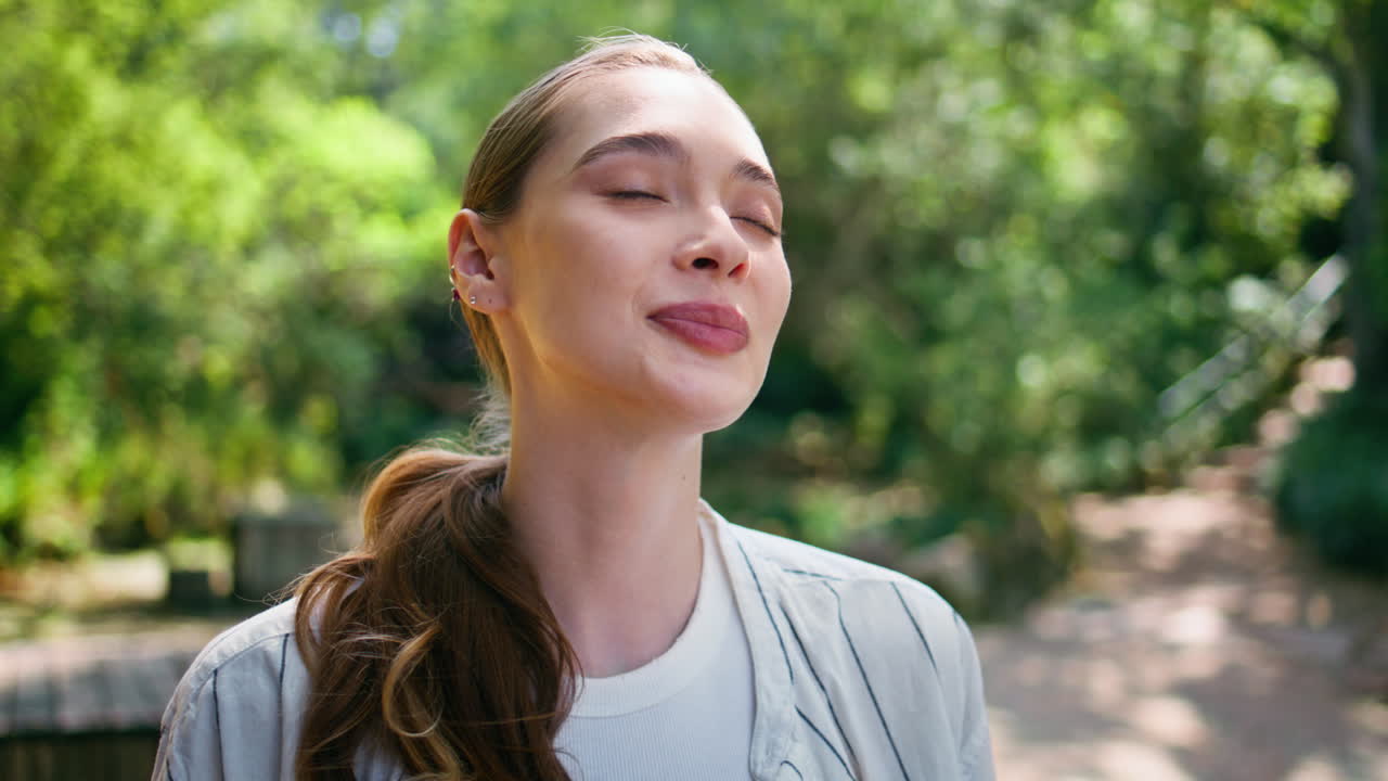 retrato de una mujer hermosa soñadora de pie en el bosque verde. niña suave cerrando los ojos