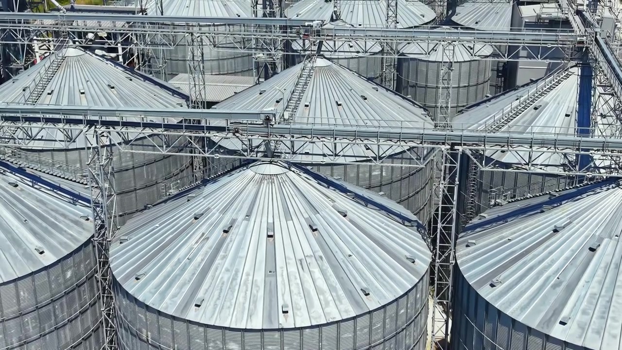 Storage silos seen from above at a grain facility during the day with clear skies