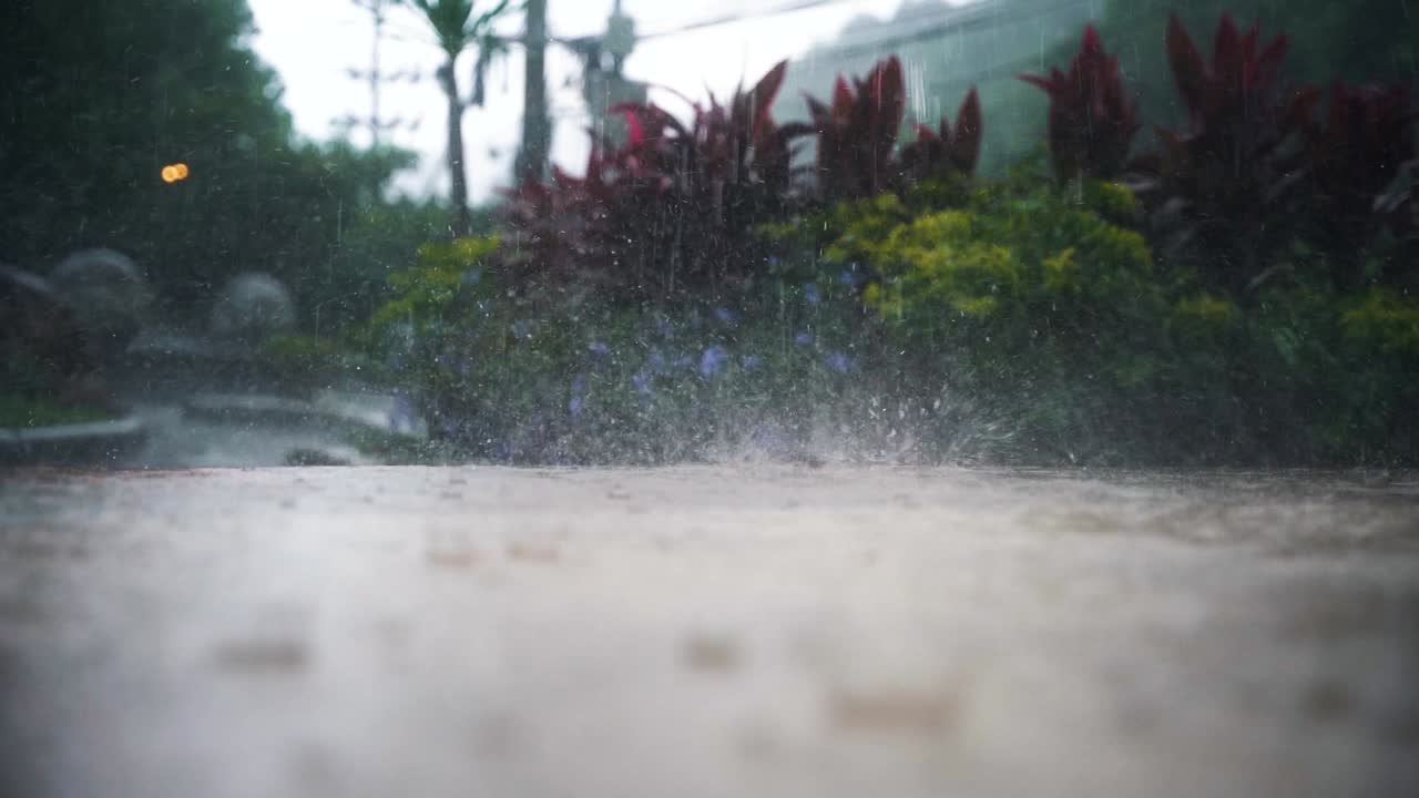 grandes gotas de lluvia caen del cielo en la calle en la que varias gotas de agua brotan del charco de lluvia en tailandia durante una fuerte lluvia