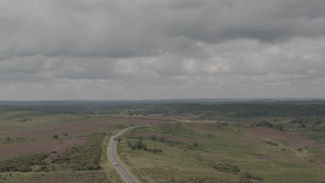toma aérea de un dron de la campiña inglesa del reino unido en el nuevo bosque con carreteras y automóviles en un clima tormentoso