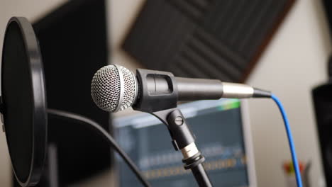 a vocal microphone and pop filter for singing or recording a podcast in a bedroom music studio slide left