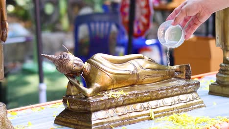 sequential water pouring on a reclining buddha statue