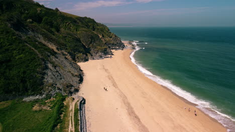 drone shot along a beach in devon uk descending in height as it goes