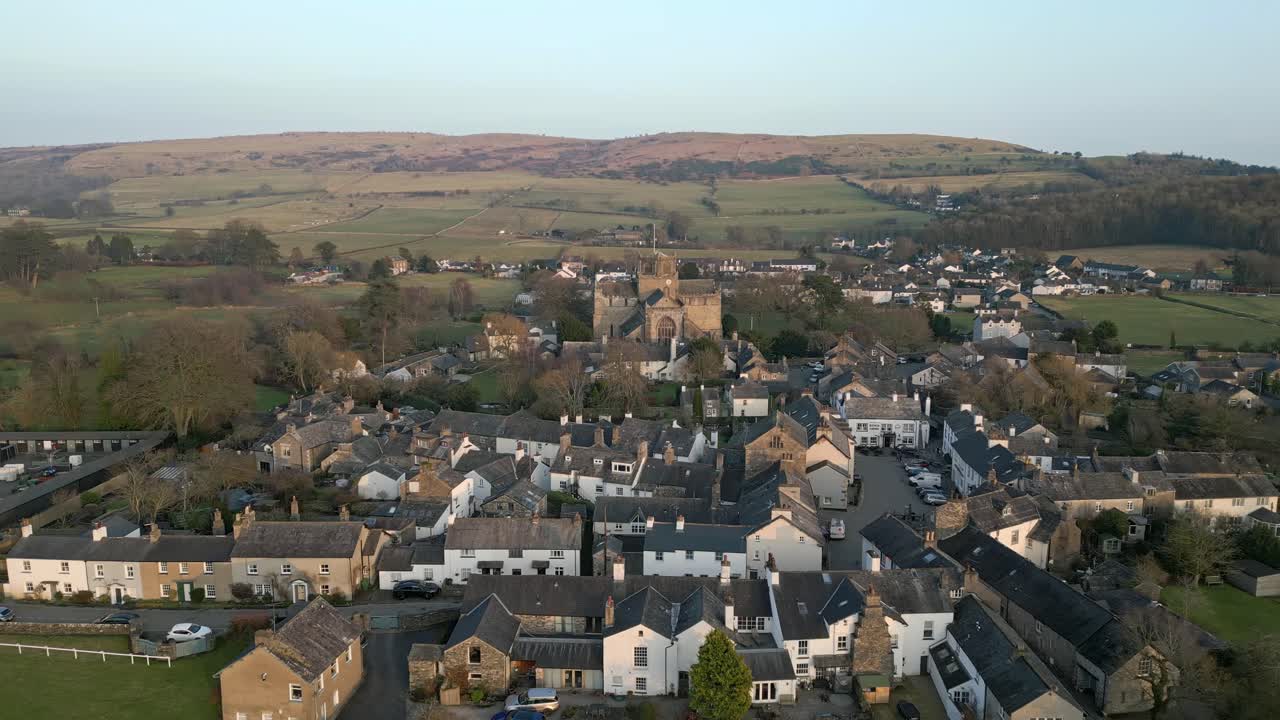 clip en cámara lenta del pueblo medieval de cartmel en cumbria que muestra el histórico priorato de cartmel al atardecer en un día de invierno