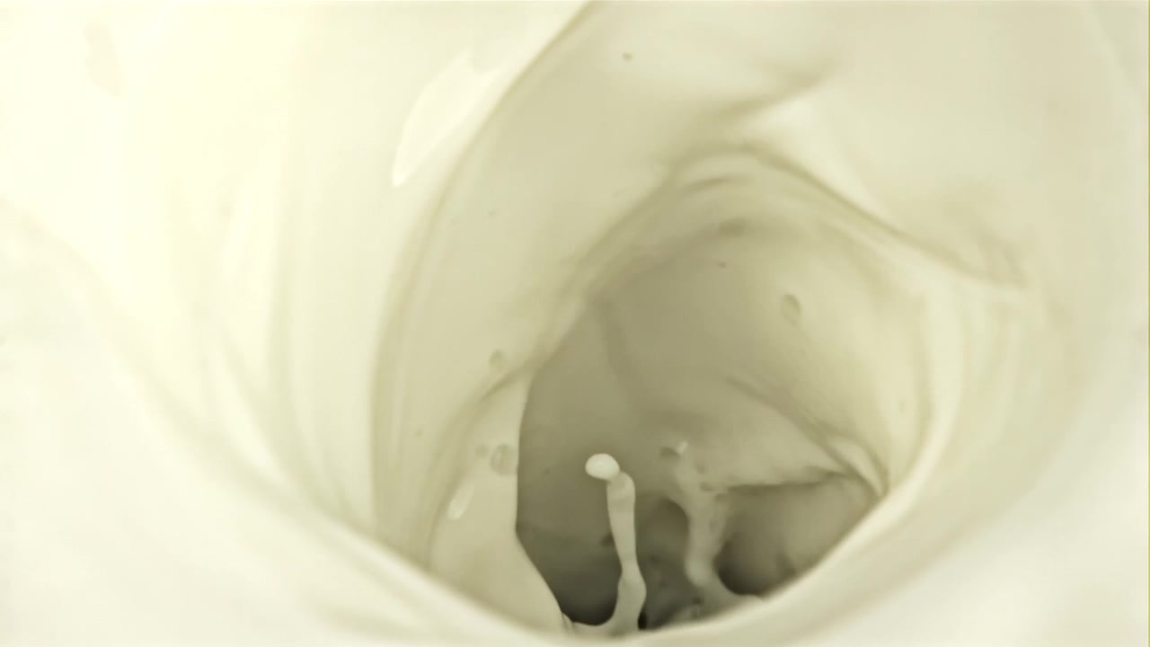 Câmera lenta de líquido branco cremoso girando em um vórtice