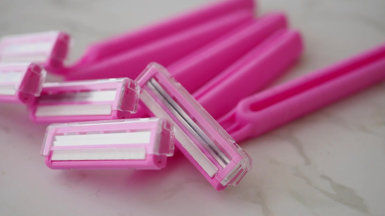 Close-up of Pink Disposable Razors on a White Surface