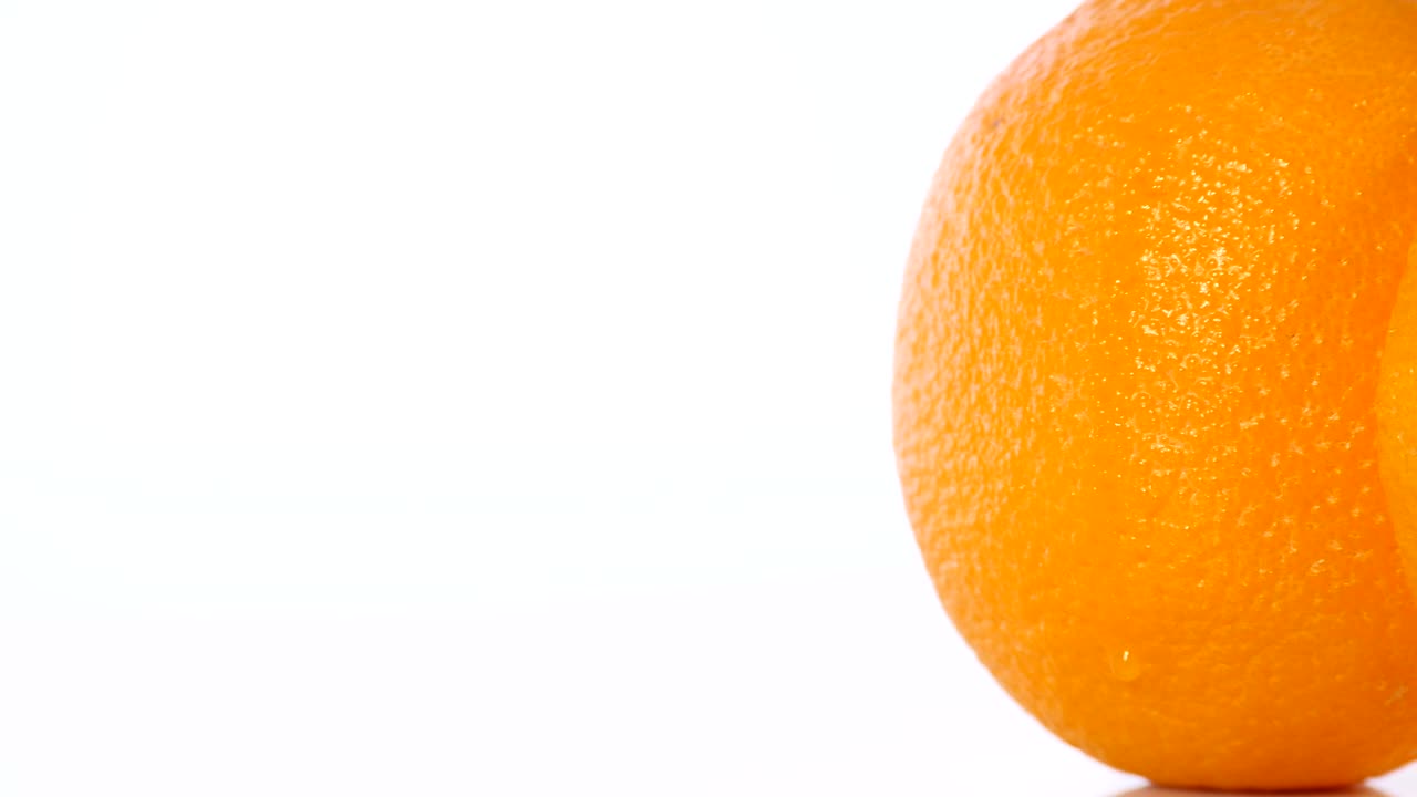 Nærbillede rotation af appelsin på en hvid baggrund.