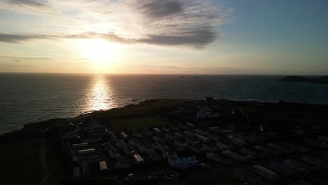 treyarnon bay caravan camp site sunset along the cornish coast from an aerial panning drone shot