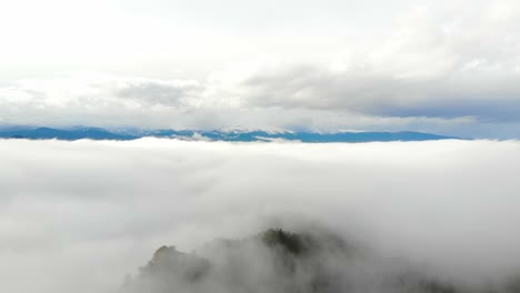 nuvole basse e alte su montagne rocciose alpine con catena montuosa sullo sfondo lontano