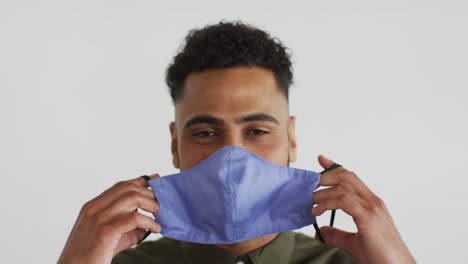 Portrait-of-mixed-race-man-putting-mask-on