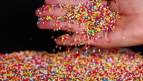 hand holding and releasing colorful sprinkles