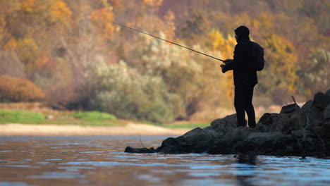 fisherman by the river in autumn