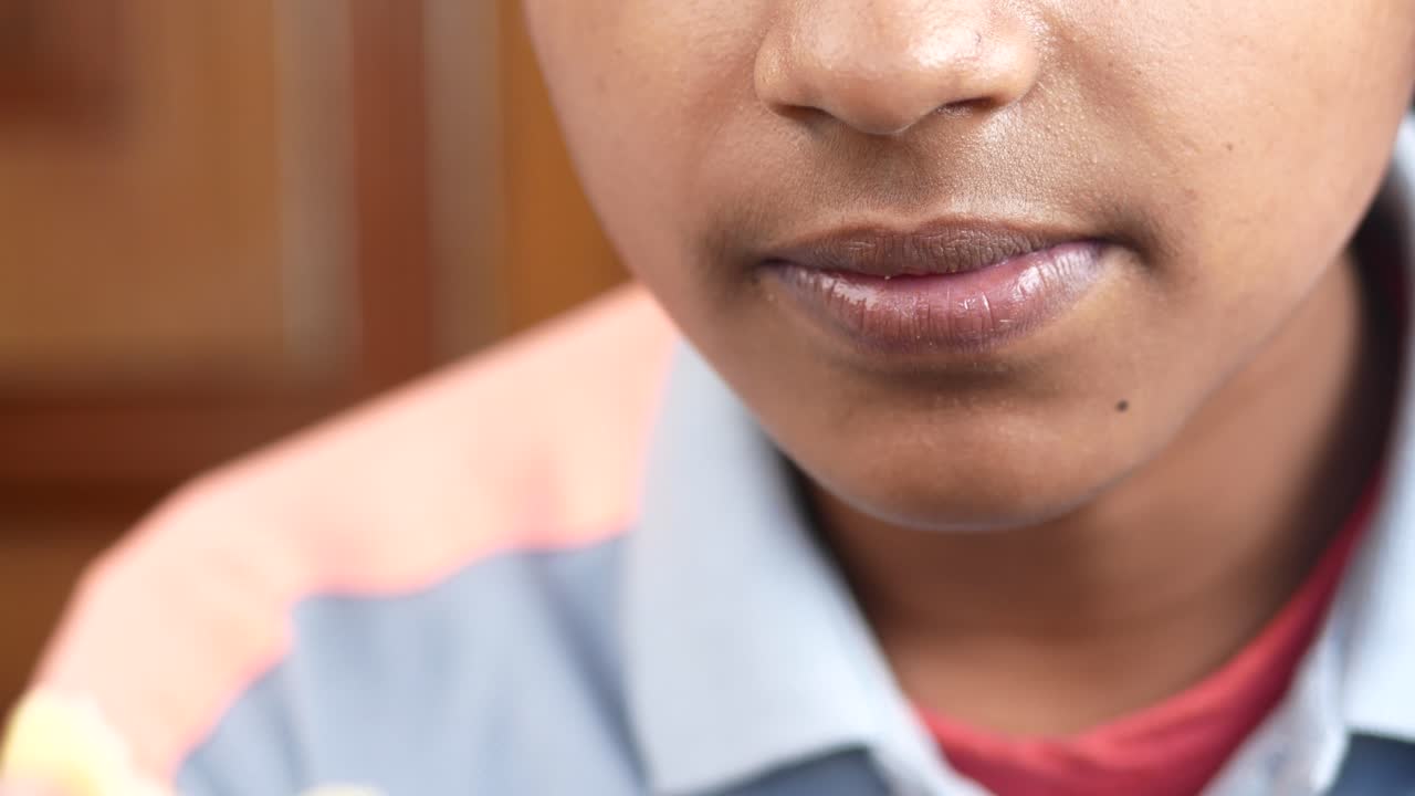 un niño adolescente comiendo papas fritas mientras está sentado