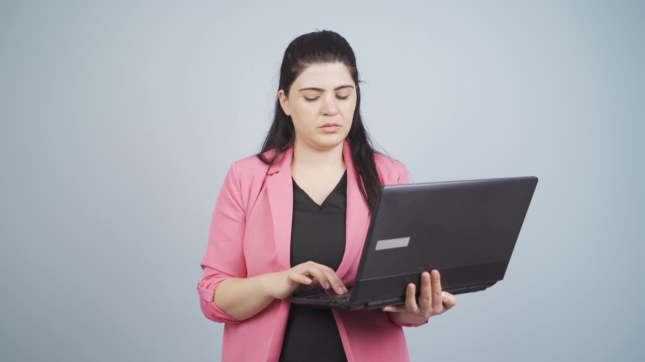 mujer de negocios mirando la computadora portátil con expresión cansada.