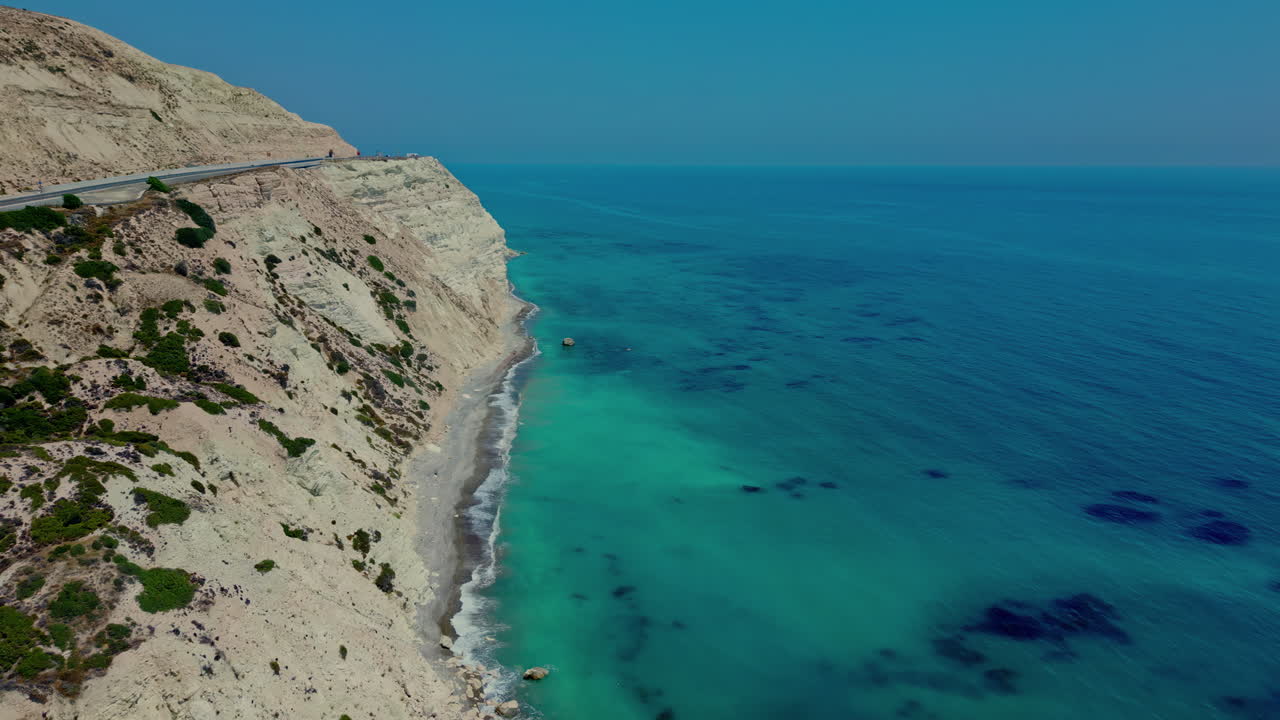 Aerial drone shot over roads along Aphrodite's Rock in Cyprus during evening time