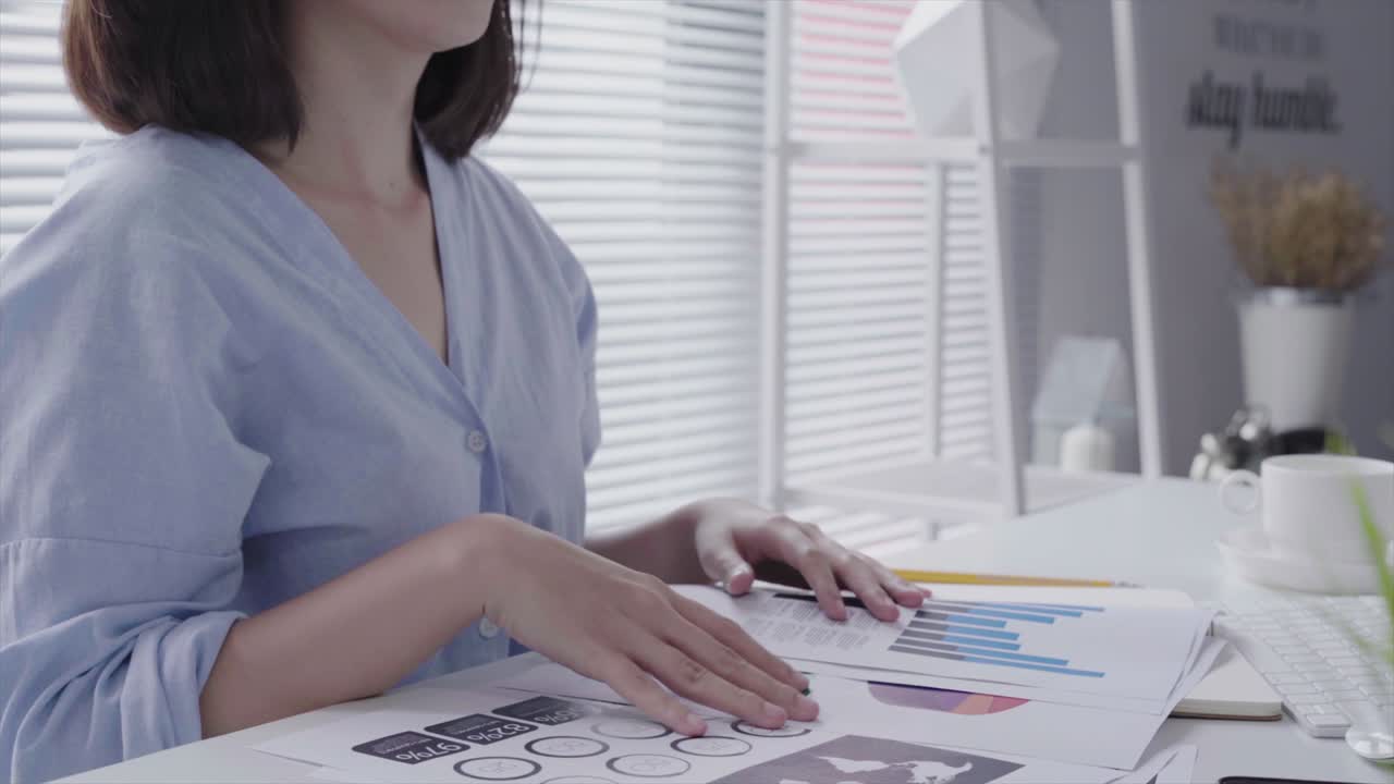 Beautiful young strain asian woman working on laptop while sitting in a living room at home. Asian business woman working in her home office.