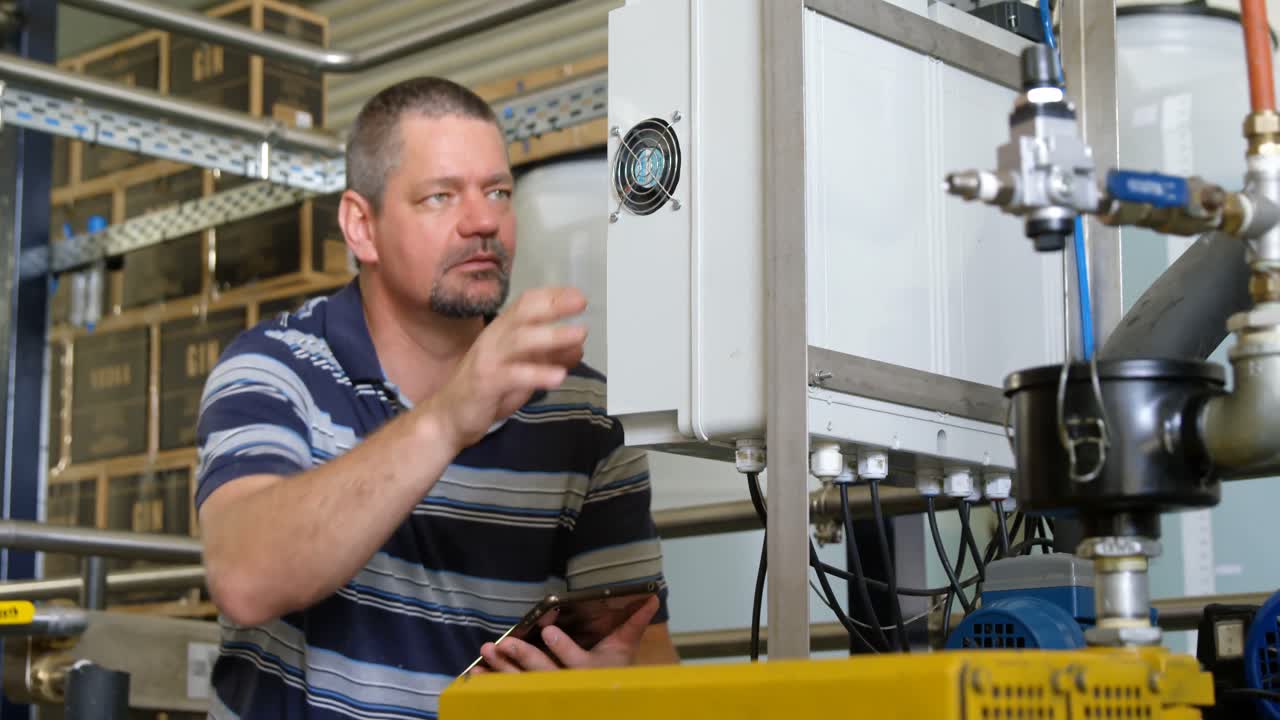 lavoratore maschio che utilizza un tablet digitale durante l'utilizzo della macchina 4k