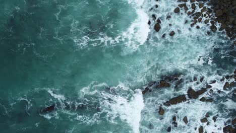 aerial view of the ocean waves dotted with rocks,