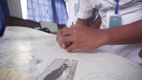 estudiante estudia la carta de navegación del barco para construir una ruta de navegación-2