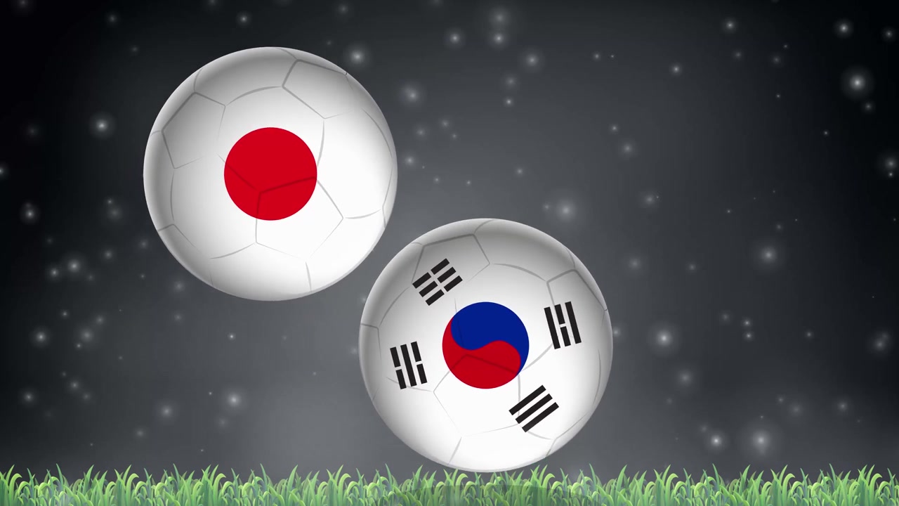 国旗柄のサッカーボールが、暗く光る背景を背に緑の芝生の上を弾む