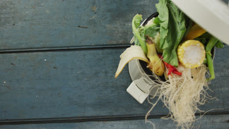 video of white compost bin with organic waste and copy space on grey wooden background