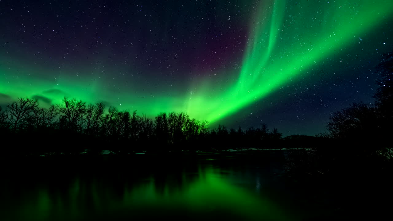 las luces del norte verdes místicas bailan en el cielo estrellado reflejadas en el río, el lapso de tiempo