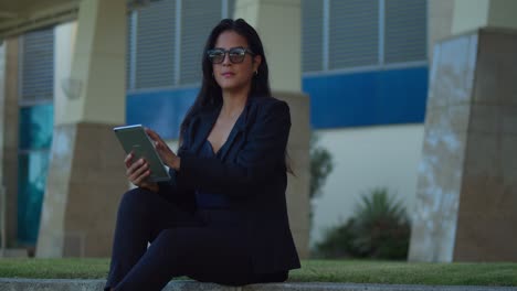 Hispanic-girl-holds-her-tablet-while-looking-out-at-an-amzing-view-in-a-Caribbean-city