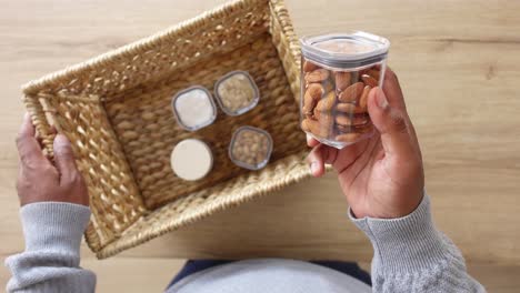 person holding a jar of almonds